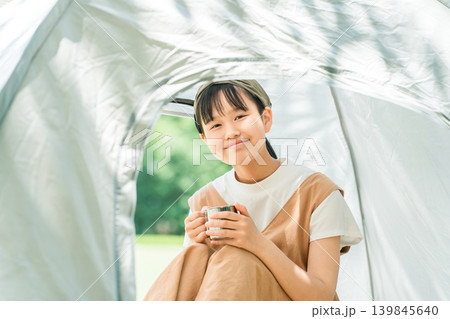 キャンプ場・レジャー施設でテントの中でドリンクを飲む女の子 139845640