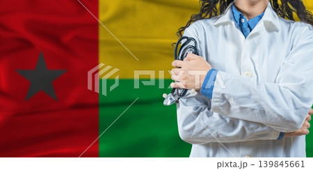 Healthcare professional with Guinea Bissau flag background. Professional doctor holding stethoscope on Guinea Bissau flag background Healthcare professional with Guinea Bissau flag background. Professional doctor holding stethoscope on Guinea Bissau flag background 139845661