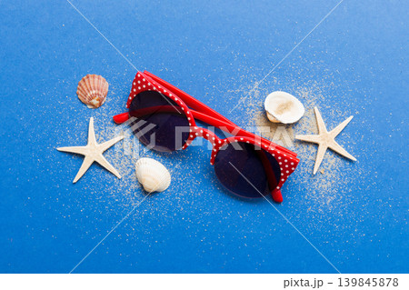 sunglasses with seashell lying on table background. Sunglasses on summer background. Top view flat lay with copy space for text sunglasses with seashell lying on table background. Sunglasses on summer background. Top view flat lay with copy space for text 139845878