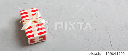 Wrapped christmas or other holiday handmade present in paper with colored ribbon. Present box, decoration of gift on table, top view with copy space Wrapped christmas or other holiday handmade present in paper with colored ribbon. Present box, decoration of gift on table, top view with copy space 139845963