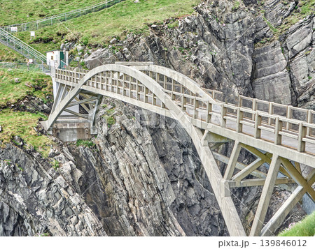 Concrete arch bridge over rocky coastal cliff 139846012