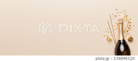 bottle of champagne with glasses and colorful confetti on colored background. top view flay lay bottle of champagne with glasses and colorful confetti on colored background. top view flay lay 139846120
