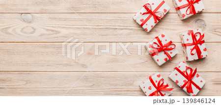Valentine day composition: red gift box with bow and heart. Christmas present. View from above. Space for text. Holday greeting card Valentine day composition: red gift box with bow and heart. Christmas present. View from above. Space for text. Holday greeting card 139846124