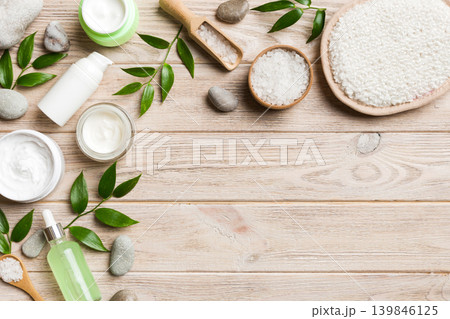 Coconut with jars of coconut oil and cosmetic cream on colored background. Top view. Free space for your text. Natural spa coconut cosmetics and organic treatment concept Coconut Spa composition 139846125