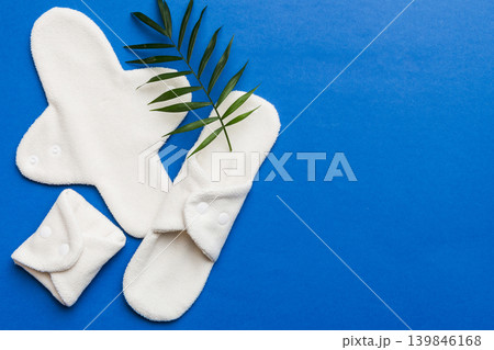 lean feminine sanitary napkin with green leaf. Absence of menstruation in woman. Minimal concept of female menopause. Copy space top view lean feminine sanitary napkin with green leaf. Absence of menstruation in woman. Minimal concept of female menopause. Copy space top view 139846168