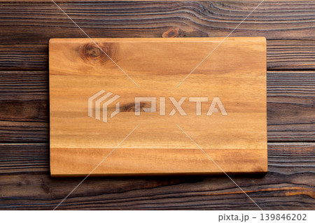 Top view of wooden cutting board on wooden background. Empty space for your design.= Top view of wooden cutting board on wooden background. Empty space for your design.= 139846202