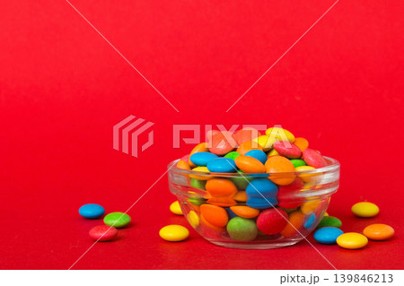 Multicolored candies in a bowl on a colored background. birthday and holiday concept. Top view with copy space 139846213