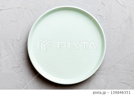 Top view of empty blue plate on cement background. Empty space for your design Top view of empty blue plate on cement background. Empty space for your design 139846351