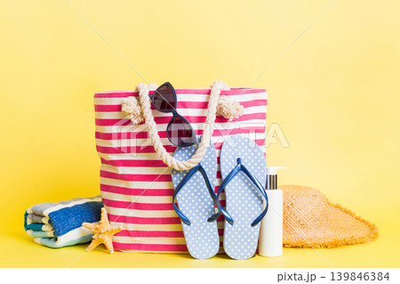 Stylish bag with beach accessories . Summer holiday concept. beach bag with straw hat with space for text Stylish bag with beach accessories . Summer holiday concept. beach bag with straw hat with space for text 139846384