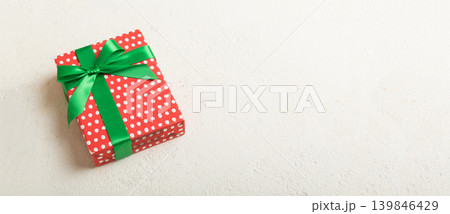 Wrapped christmas or other holiday handmade present in paper with colored ribbon. Present box, decoration of gift on table, top view with copy space Wrapped christmas or other holiday handmade present in paper with colored ribbon. Present box, decoration of gift on table, top view with copy space 139846429