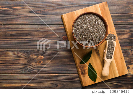 Chia seeds in bowl and spoon on colored background. Healthy Salvia hispanica in small bowl. Healthy superfood Chia seeds in bowl and spoon on colored background. Healthy Salvia hispanica in small bowl. Healthy superfood 139846433