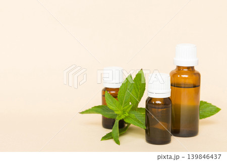 Natural Mint Essential Oil in a Glass Bottle. organic cosmetics with herbal extracts of mint on colored background 139846437