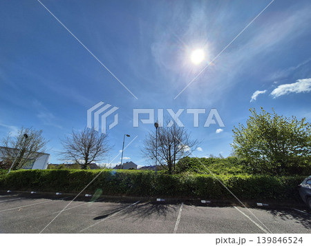 Clear Sky with Clouds Over Green Grass and Street Light by the Asphalt Road, Tree in Background, Sunlight Illuminating the Scene Clear Sky with Clouds Over Green Grass and Street Light by the Asphalt Road, Tree in Background, Sunlight Illuminating the Scene 139846524