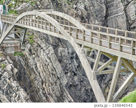 Concrete arch bridge crossing rocky mountain gorge 139846543