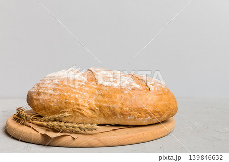 Freshly baked bread on cutting board against white wooden background. perspective view bread with copy space 139846632
