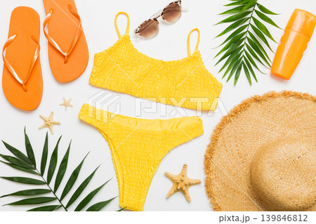 Woman swimwear and beach accessories flat lay top view. Top view with bikini outfit on color background. Vacation concept copy space Woman swimwear and beach accessories flat lay top view. Top view with bikini outfit on color background. Vacation concept copy space 139846812
