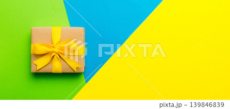 holiday paper present tied yellow ribbon bow top view with copy space. Flat lay holiday background. Birthday or christmas present. Christmas gift box concept with copy space holiday paper present tied yellow ribbon bow top view with copy space. Flat lay holiday background. Birthday or christmas present. Christmas gift box concept with copy space 139846839