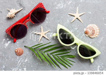 sunglasses with seashell lying on table background. Sunglasses on summer background. Top view flat lay with copy space for text 139846854