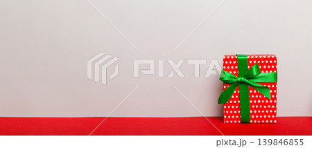 holiday paper present tied yellow ribbon bow top view with copy space. Flat lay holiday background. Birthday or christmas red present. Christmas gift box concept with copy space holiday paper present tied yellow ribbon bow top view with copy space. Flat lay holiday background. Birthday or christmas red present. Christmas gift box concept with copy space 139846855