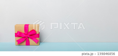 holiday paper present tied pink ribbon bow top view with copy space. Flat lay holiday background. Birthday or christmas present. Christmas gift box concept with copy space 139846856
