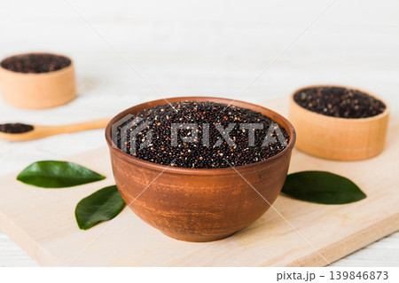 quinoa seeds in bowl and spoon on colored background. Healthy kinwa in small bowl. Healthy superfood quinoa seeds in bowl and spoon on colored background. Healthy kinwa in small bowl. Healthy superfood 139846873