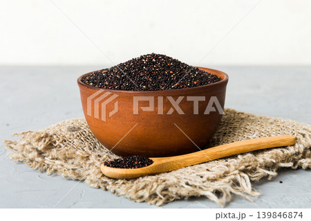 quinoa seeds in bowl and spoon on colored background. Healthy kinwa in small bowl. Healthy superfood quinoa seeds in bowl and spoon on colored background. Healthy kinwa in small bowl. Healthy superfood 139846874