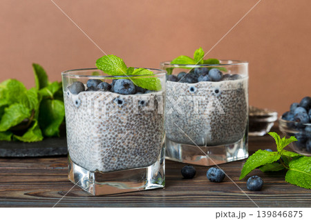 Healthy breakfast or morning with chia seeds vanilla pudding and blueberry berries on table background, vegetarian food, diet and health concept. Chia pudding with coconut milk and blueberry Healthy breakfast or morning with chia seeds vanilla pudding and blueberry berries on table background, vegetarian food, diet and health concept. Chia pudding with coconut milk and blueberry 139846875