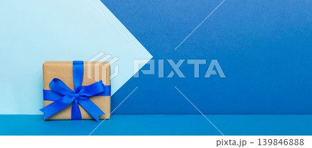 holiday handmade paper present tied blue ribbon bow top view with copy space. Flat lay holiday background. Birthday or christmas present. Christmas gift box concept with copy space 139846888