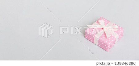 wrapped Christmas or other holiday handmade gift box in color paper with ribbon on colored background. Present box, decoration of gift on colored table, top view with copy space 139846890