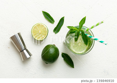 Caipirinha, Mojito cocktail, vodka or soda drink with lime, mint and straw on table background. Refreshing beverage with mint and lime in glass top view flat lay Caipirinha, Mojito cocktail, vodka or soda drink with lime, mint and straw on table background. Refreshing beverage with mint and lime in glass top view flat lay 139846910