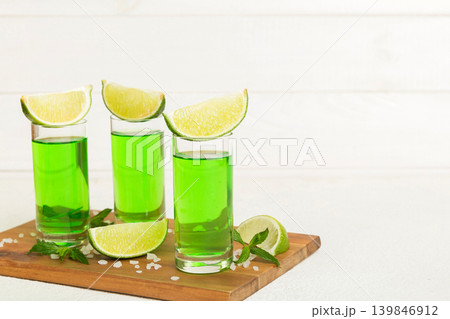 Sweet refreshing mint liqueur, with ice and mint leaves on table background, Shots with lime slice and mint flat lay 139846912
