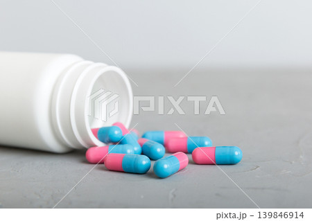 plastic medicine bottle with capsules of pills on colored background. Online pharmacy. Painkiller medicine and antibiotic drug resistance concept. Pharmaceutical industry plastic medicine bottle with capsules of pills on colored background. Online pharmacy. Painkiller medicine and antibiotic drug resistance concept. Pharmaceutical industry 139846914