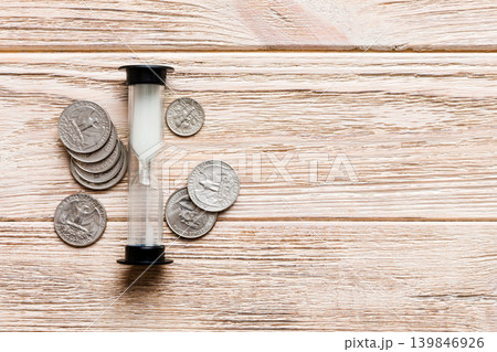Deadline and time is money concept with hourglass and US coins currency. sand clock time for saving concept Deadline and time is money concept with hourglass and US coins currency. sand clock time for saving concept 139846926