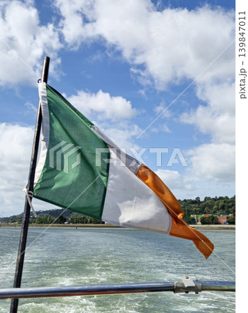 Irish Flag Waving Over River Background Irish Flag Waving Over River Background 139847011