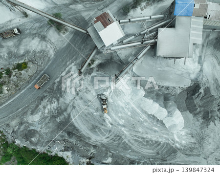 Aerial view of granite and limestone crushing plant with dump trucks and excavators processing raw stone into construction aggregates for concrete and infrastructure development. Stone mill factory. 139847324