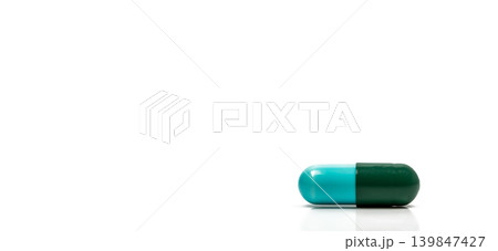 Blue and green antibiotic capsule pills isolated on white background in global healthcare concept showing antimicrobial resistance awareness and responsible drug use for infection treatment. Blue and green antibiotic capsule pills isolated on white background in global healthcare concept showing antimicrobial resistance awareness and responsible drug use for infection treatment. 139847427