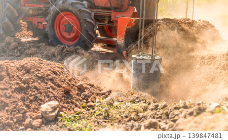 Construction tractor with specialized dozer blade pushing and grading soil at excavation site. Heavy machinery transforming raw land into prepared foundation for upcoming building development project. Construction tractor with specialized dozer blade pushing and grading soil at excavation site. Heavy machinery transforming raw land into prepared foundation for upcoming building development project. 139847481