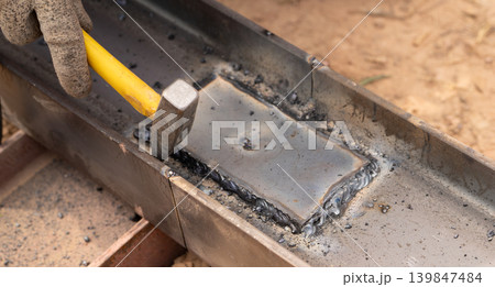 Skilled worker hammers hot metal weld in industrial workshop, capturing the artistry of metalworking, the precision of craftsmanship, and the sparks flying from the intense heat of forging. Skilled worker hammers hot metal weld in industrial workshop, capturing the artistry of metalworking, the precision of craftsmanship, and the sparks flying from the intense heat of forging. 139847484