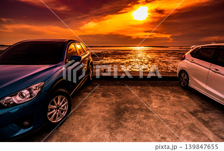 SUV car with modern sporty design parked on coastal concrete road at sunset, environmentally friendly transportation concept. Clean energy technology, sustainable mobility and scenic seaside travel. SUV car with modern sporty design parked on coastal concrete road at sunset, environmentally friendly transportation concept. Clean energy technology, sustainable mobility and scenic seaside travel. 139847655
