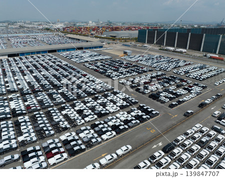 Aerial view of new cars stock at factory parking lot. Above view cars parked in a row. Automotive industry. Logistics business. Import or export new cars at warehouse. Big parking lot at port terminal Aerial view of new cars stock at factory parking lot. Above view cars parked in a row. Automotive industry. Logistics business. Import or export new cars at warehouse. Big parking lot at port terminal 139847707