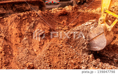 Backhoe digging soil at construction site. Bucket of backhoe digging soil. Crawler excavator digging on dirt. Excavating machine. Earth moving machine. Excavation vehicle. Backhoe working on suny day. Backhoe digging soil at construction site. Bucket of backhoe digging soil. Crawler excavator digging on dirt. Excavating machine. Earth moving machine. Excavation vehicle. Backhoe working on suny day. 139847798