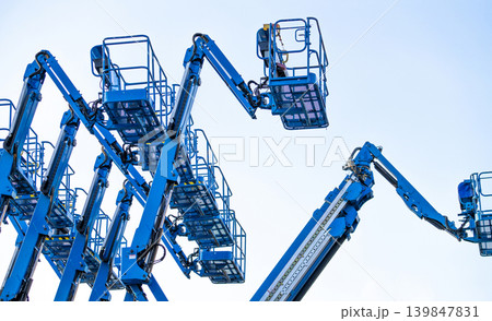 Articulated boom lift. Aerial platform lift. Telescopic boom lift against clear sky. Mobile construction crane for rent and sale. Maintenance and repair hydraulic boom lift service. Crane dealership. 139847831