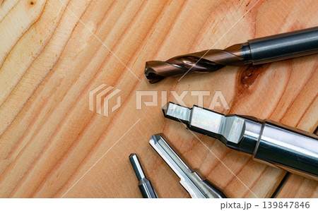 Special tools isolated on wooden table. Made to order special tools. Coated step drill and reamer detail. HSS cemented carbide. Carbide cutting tool for industrial applications. Engineering tools. Special tools isolated on wooden table. Made to order special tools. Coated step drill and reamer detail. HSS cemented carbide. Carbide cutting tool for industrial applications. Engineering tools. 139847846