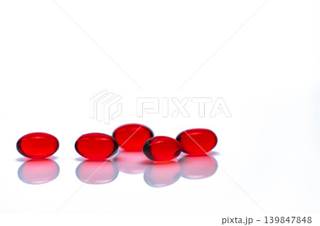 Red soft gel capsule pills isolated on white background. Pile of red soft gelatin capsule. Vitamins and dietary supplements concept. Pharmaceutical industry. Pharmacy drug store. Health care products. Red soft gel capsule pills isolated on white background. Pile of red soft gelatin capsule. Vitamins and dietary supplements concept. Pharmaceutical industry. Pharmacy drug store. Health care products. 139847848