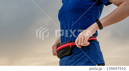 Young Asian woman wear wristband and waist belt. Running cardio exercise in the morning concept. Outdoor workout. Runner and smart band wearable device. Gadget for healthy lifestyle. Marathon fashion. Young Asian woman wear wristband and waist belt. Running cardio exercise in the morning concept. Outdoor workout. Runner and smart band wearable device. Gadget for healthy lifestyle. Marathon fashion. 139847910