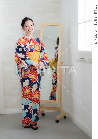 鏡で浴衣姿を確認する日本人女性の着付け準備イメージ　カメラ目線笑顔 139849411