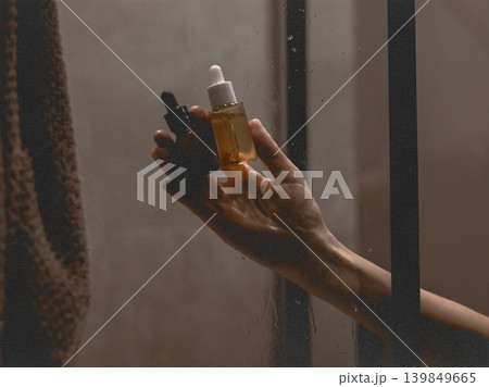 Female hand holding skincare serums in a steamy shower, highlighting a modern beauty routine. Self-care daily routine lifestyle moment. Spa routine. Female hand holding skincare serums in a steamy shower, highlighting a modern beauty routine. Self-care daily routine lifestyle moment. Spa routine. 139849665