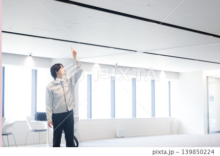 ビルの設備点検を行う若手技術者のメンテナンスイメージ　天井を指を差す全身 139850224