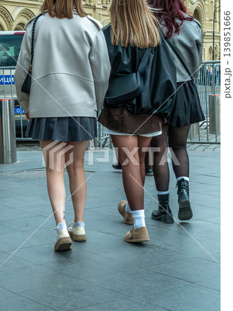 Three Friends Walking in City Street Wearing Skirts and Casual Fashion Back View 139851666
