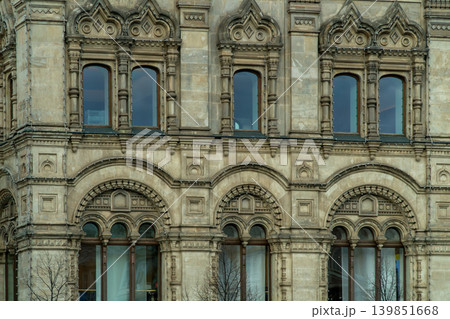 Historic Stone Facade With Ornate Arched Windows And Decorative Architectural Details On Urban Building 139851668
